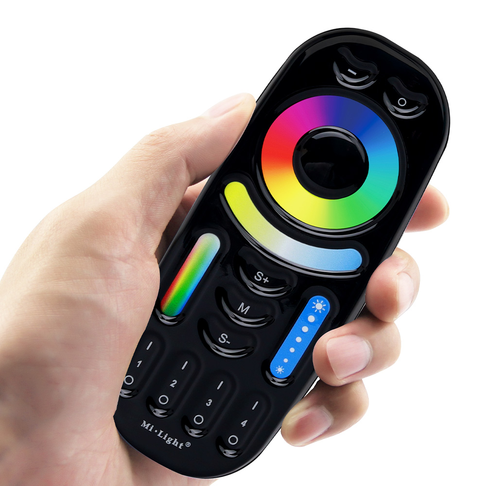 Crni RGB+CCT daljinski u ruci, sa prstenom boja, lukom za belu i tasterima za četiri zone