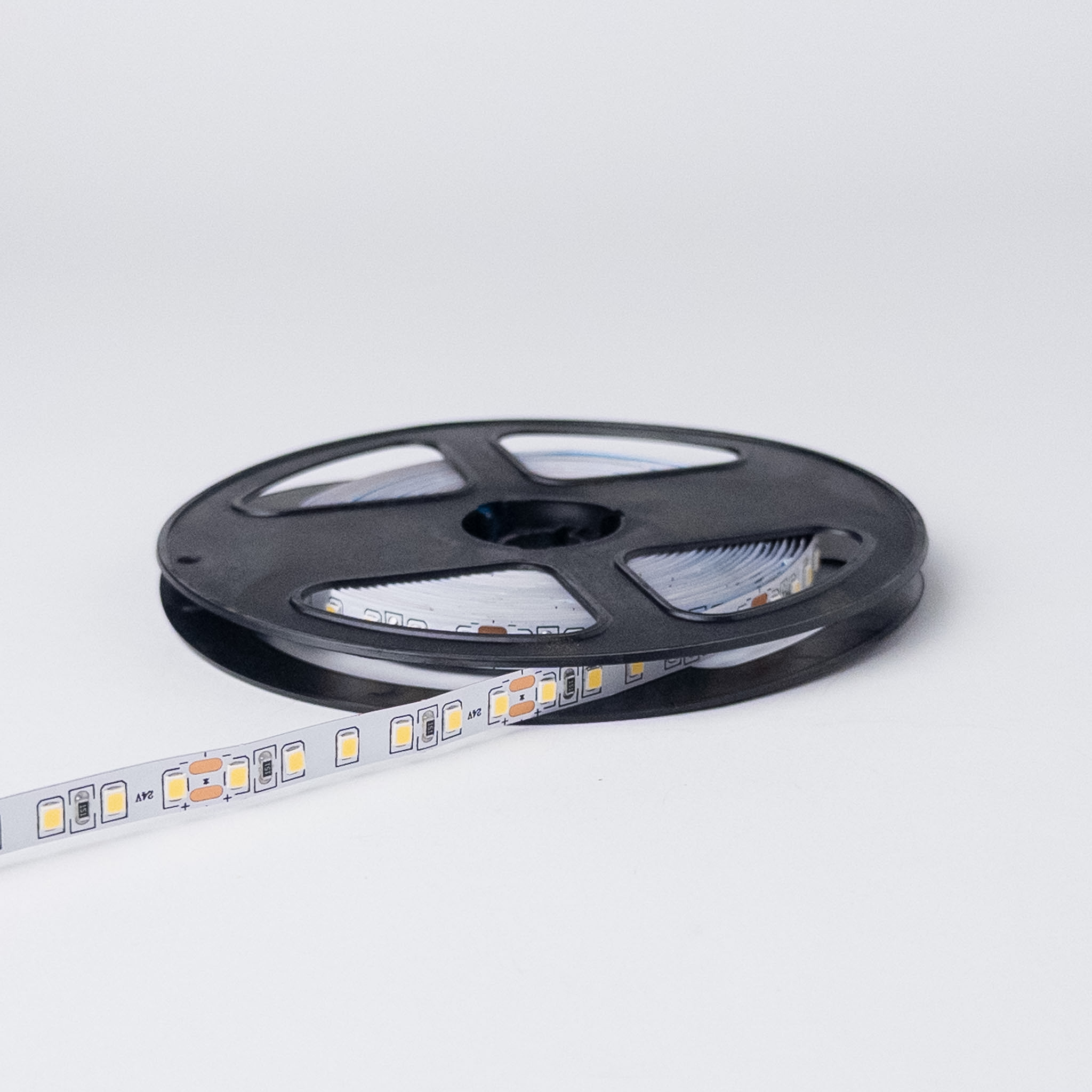 LED traka 6000K CRI 95 na crnom plastičnom koturu, ugašena, sa natpisom 24V i parovima bakarnih polja