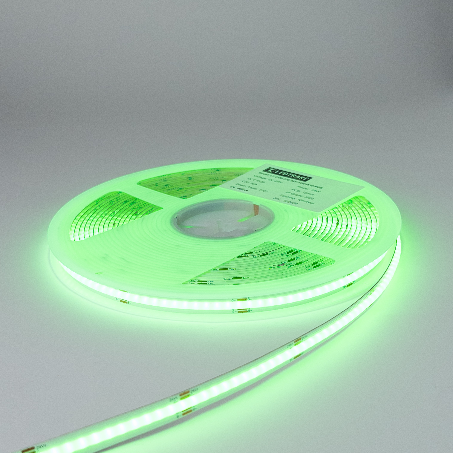 Kotur RGB trake od 24 V upaljen u zelenoj boji, sa zelenim odsjajem po podlozi